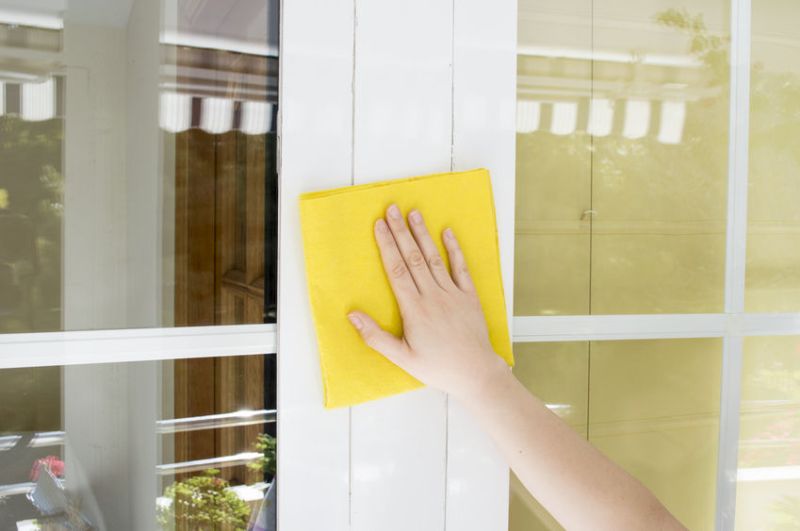 24364997 - hand cleaning aluminum window white with yellow cloth