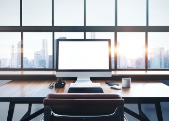 46966161 - photo of generic design computer screen and workspace in loft with panoramic windows and city on the background