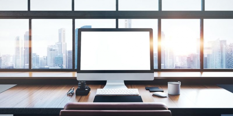 46966161 - photo of generic design computer screen and workspace in loft with panoramic windows and city on the background